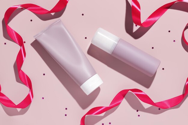 Blank pink plastic cosmetic tubes with pink ribbons Cosmetic beauty product branding mockup