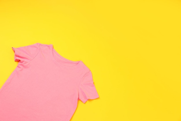 노란색 배경에 인쇄할 수 있는 공간이 있는 빈 분홍색 티셔츠