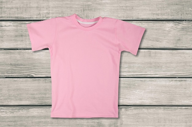 Photo blank pink t-shirt on wooden background