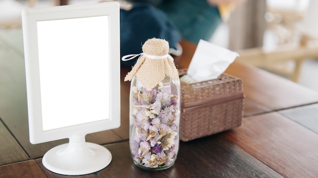 Photo blank placard to insert text in the tableware advertising with a flowerpot on the side.