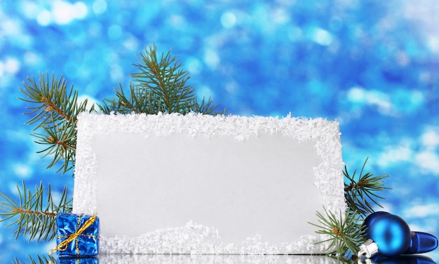 Photo blank postcard, christmas balls and fir-tree on blue background