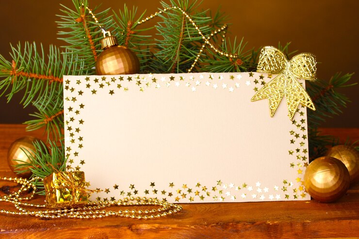 फोटो blank postcard, christmas balls and fir-tree on wooden table on brown background
