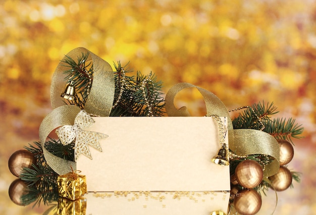 Blank postcard, Christmas balls and fir-tree on yellow background