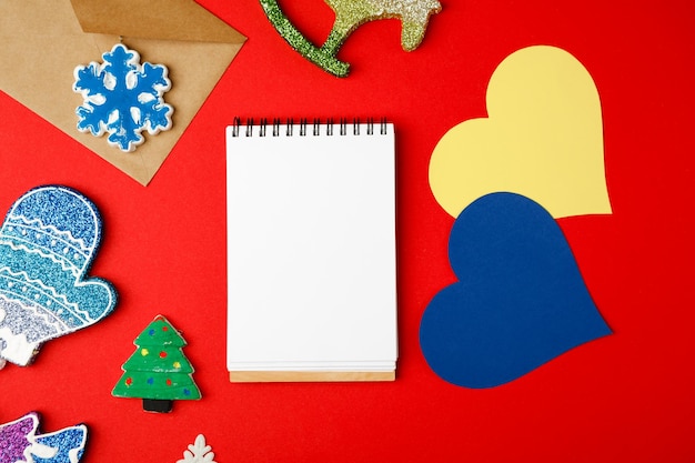 Фото Пустой конверт открытки и рождественский декор на красном фоне копией пространства