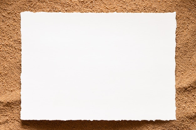 Blank postcard template on sand background.