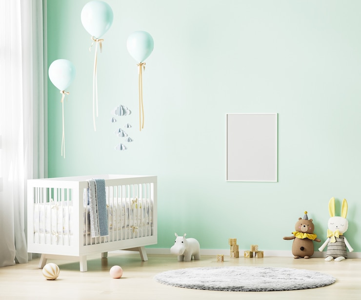 Photo blank poster frame on green wall in nursery room interior background with baby bedding