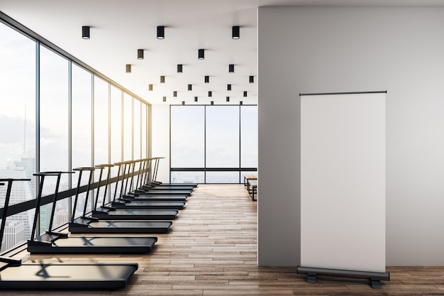 Blank poster on wooden floor in modern gym in skyscraper