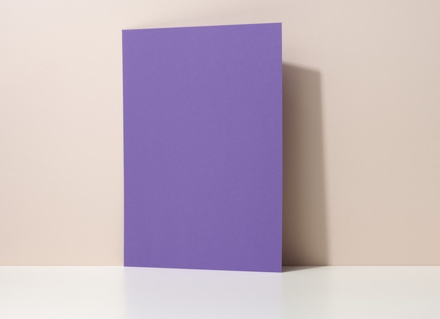 Photo blank purple cardboard sheet of paper with shadow on white table. template for flyer, announcement