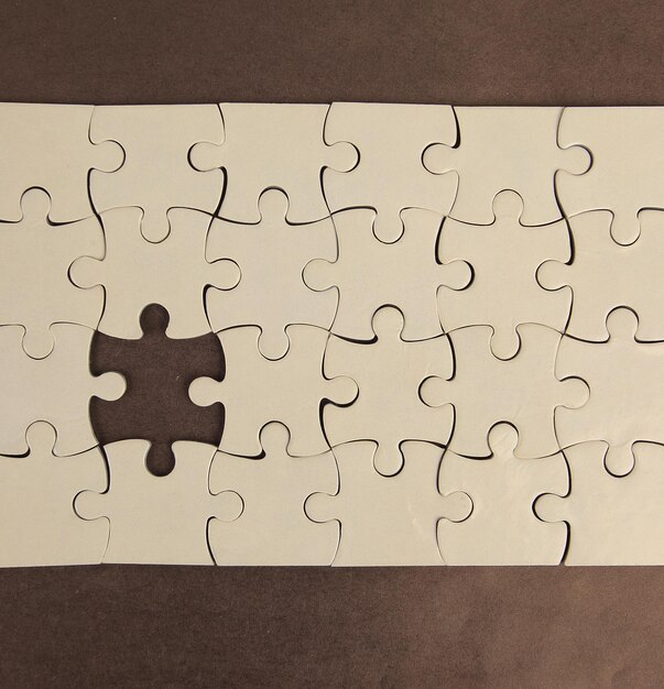 Blank puzzle with missing pieceon a brown background