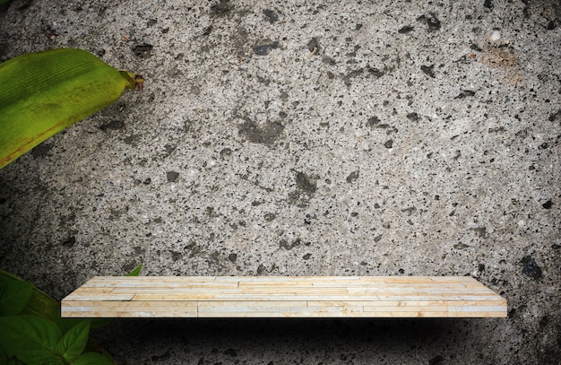 Blank rock stone display shelf on plant cement wall