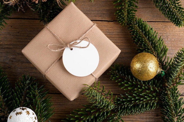 Blank round Christmas gift tag mockup with present box product label mockup with natural fir tree branch