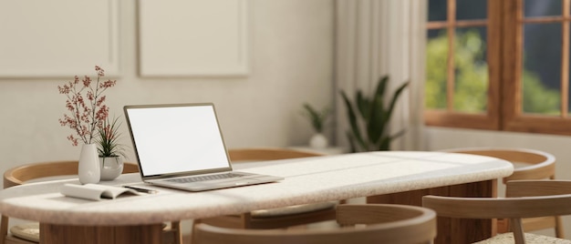 A blank screen laptop mockup on a table in a minimal Scandinavian room interior