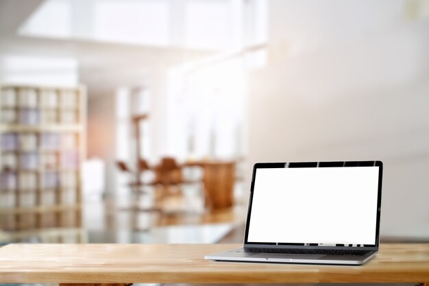 Blank screen laptop on wood desk.