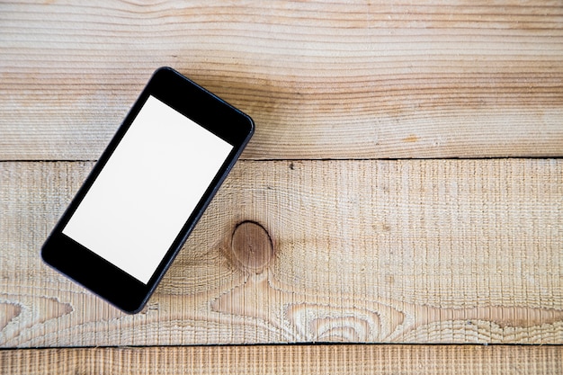 blank screen smartphone on wood table 