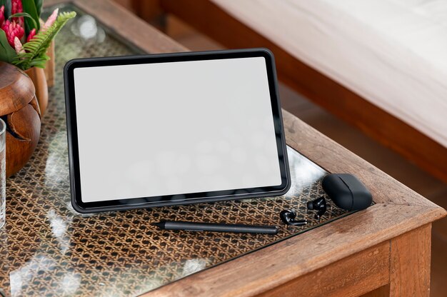 Blank screen tablet and gadget on wooden table.