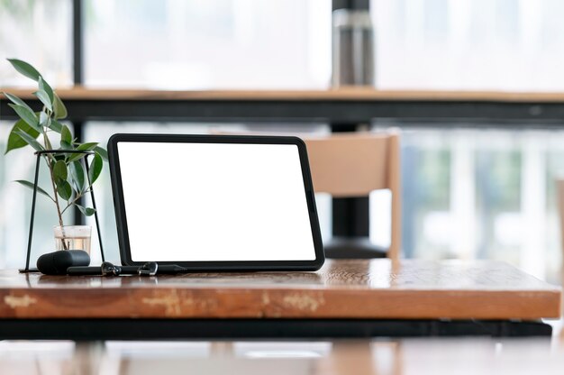 コピースペースと共同作業スペースの木製テーブルの上の空白の画面のタブレット。