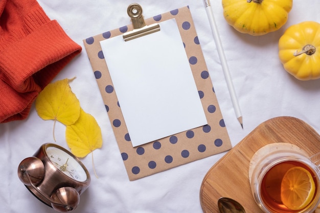 Blank sheet of paper and autumn cozy decor top view Copy space for autumn text