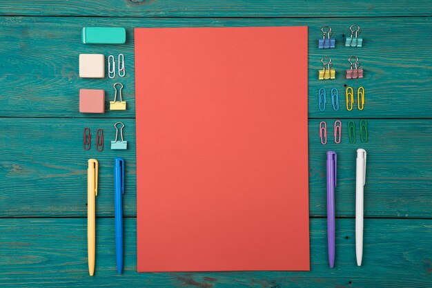 Blank sheet of paper and colorful office accessories