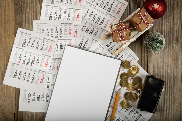 Photo blank sheet of paper and small purse with coins on the new years background top view