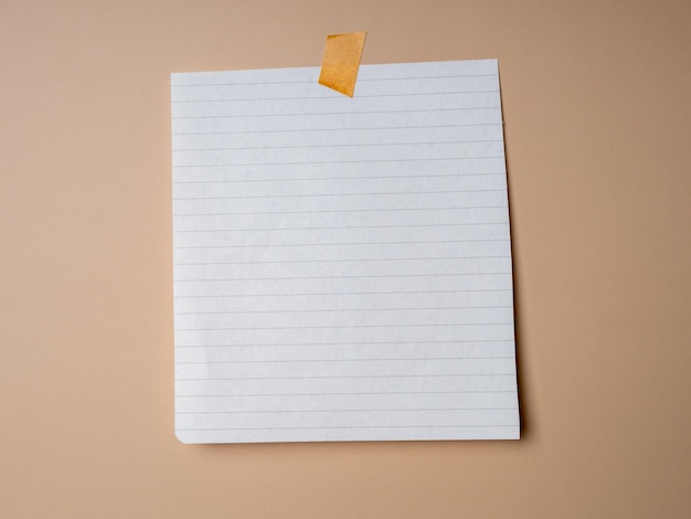 Blank sheet of paper with stripes taped on a beige background