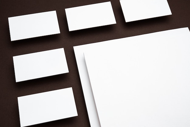 Пустые листы, плавающие над коричневым фоном, творческие. Белые карты. Современный макет для рекламы в офисном стиле. Пустой белый Copyspace для концепции дизайна, бизнеса и финансов.