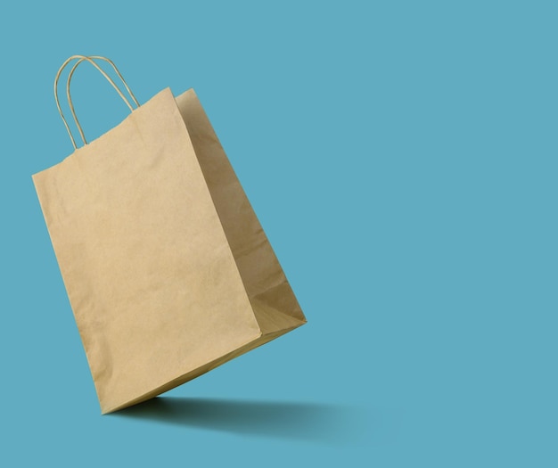 Blank shopping paper bag on blue background