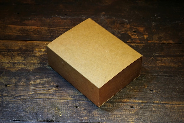 Photo blank small cardboard box on wooden background