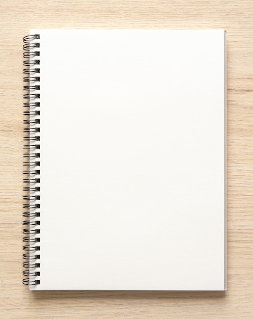 Blank spiral bound notepad mockup template with Kraft Paper cover, isolated on wood background. High resolution.