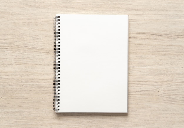 Blank spiral bound notepad mockup template on wood background. High resolution.