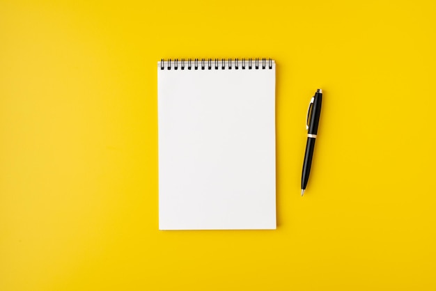 Photo blank spiral notebook with fountain pen on colorful yellow background top view copyspace