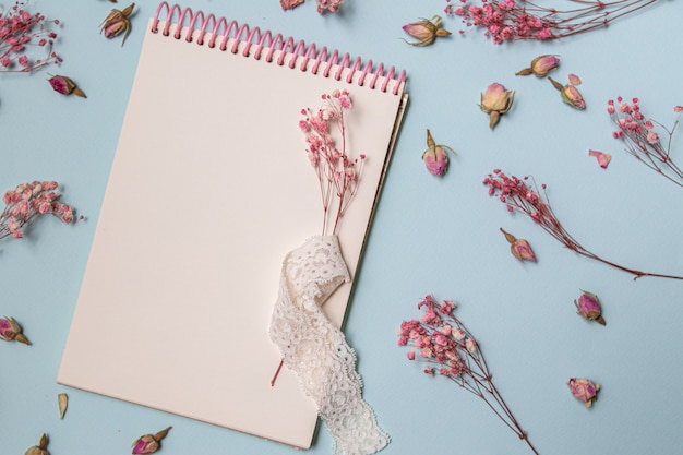 blank spiral notebook with single flower, decorated with dry sprigs of flowers