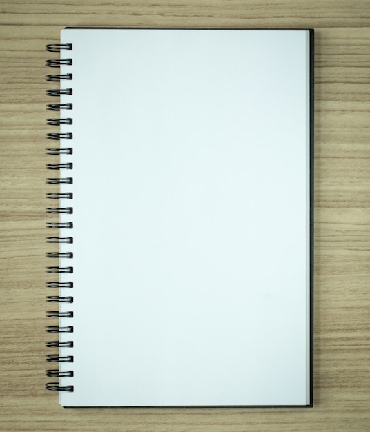 blank spiral notebook on wood background