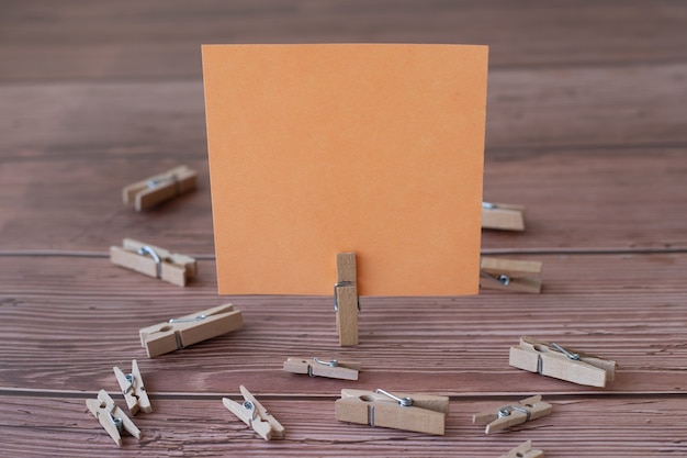 Blank square note surrounded by laundry clips showing new meaning empty piece of sticky paper