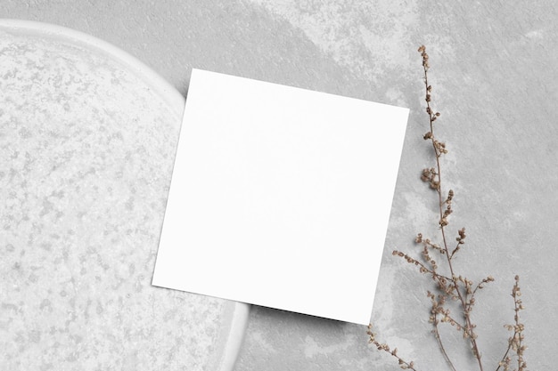 写真 植物の装飾が施された空白の正方形の紙の結婚式またはグリーティングカードのモックアップ