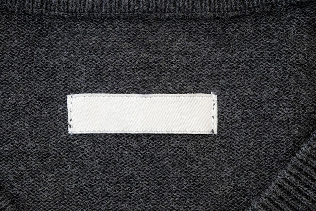 Photo blank stripe label for branding on sweater tag mockup on gray cloth top view