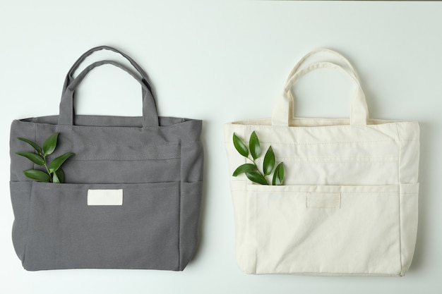 Фото Пустые стильные эко-сумки с веточками на белой поверхности