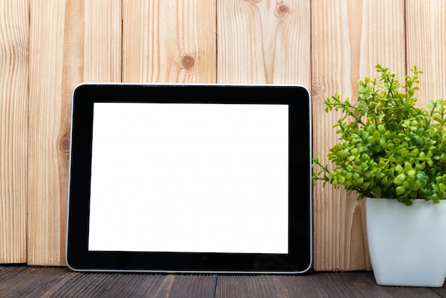 Blank tablet computer and little tree on wood