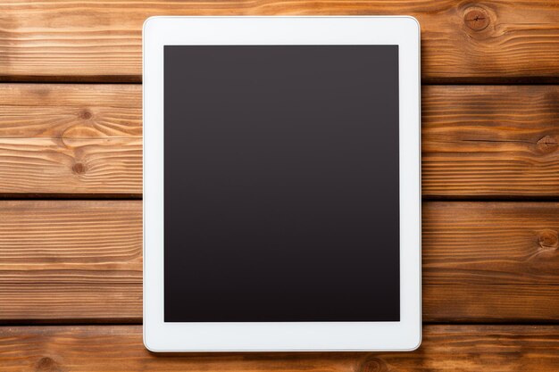 Photo blank tablet computer on wood table background