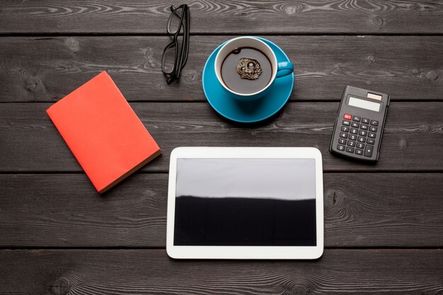 blank tablet device over a wooden workspace table with coffee top view