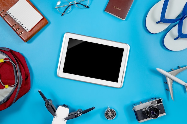 Blank Tablet screen surrounding by summer travel objects