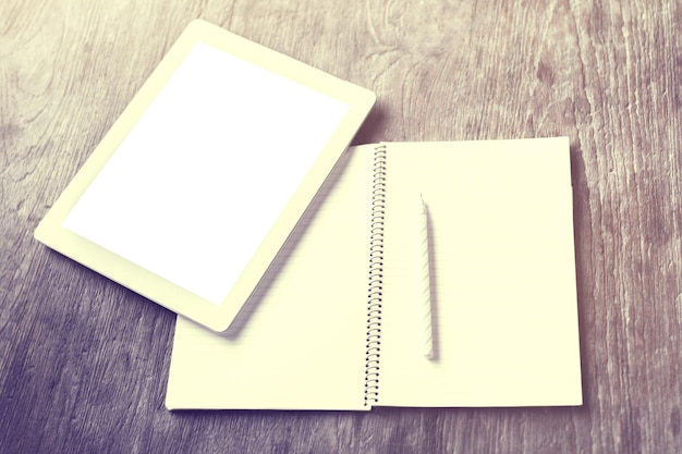 Blank tablet with blank diary and pen on a wooden table