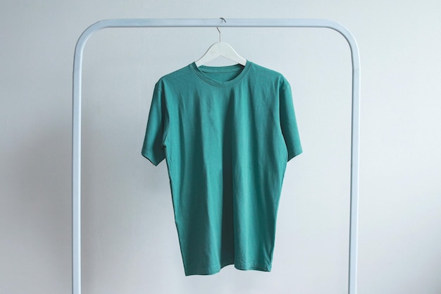 Blank tosca tshirt mockup hanging on a white rack clothes front view