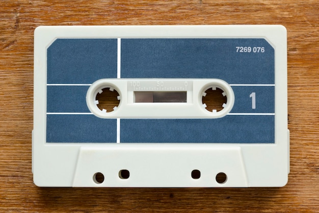 Blank vintage cassette from early 80's on red wood background
