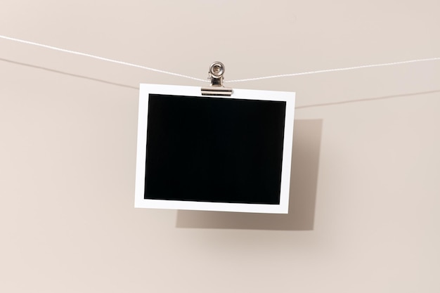 Blank vintage instant photo frame hanging on a rope