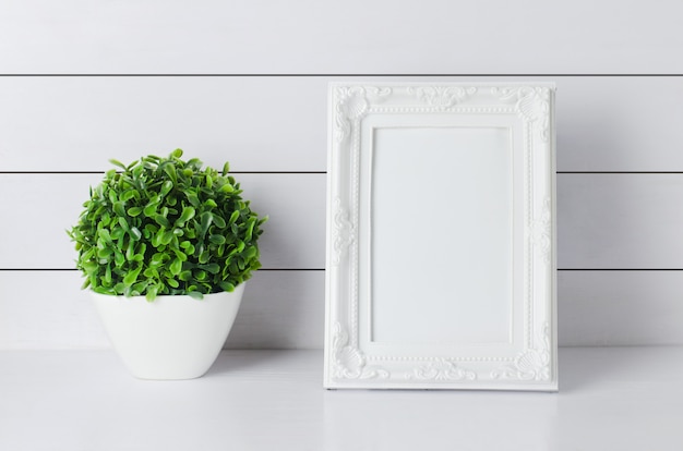 Blank vintage photo frame with green home plant