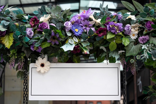 Scena di mockup del segno della scheda di nozze vuota scheda di benvenuto bianca vuota con fiori ghirlanda floreale sulla decorazione della festa di compleanno ad arco