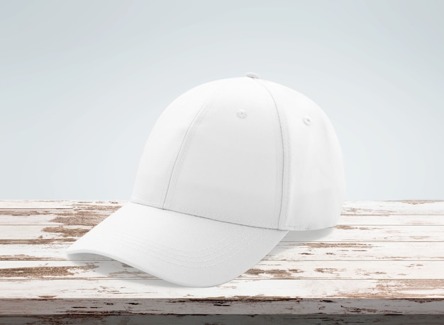 Blank white baseball cap mockup on wooden desk