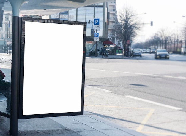 Blank white billboard sign at a bus stop in a city