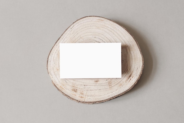Пустой белый макет визитной карточки на деревянной доске для нарезки серый фон стола современный минималистский шаблон фирменный стиль естественный зимний дизайн плоский вид сверху