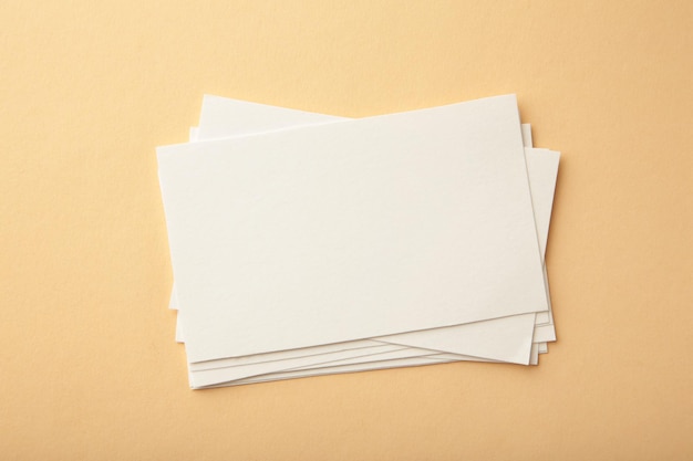 Blank white business cards on beige paper background Mockup for branding identity Template for graphic designers portfolios